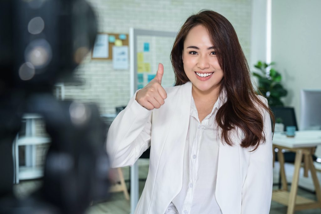 Portrait of Asian Business woman with thumbs up like when recording video for social influence